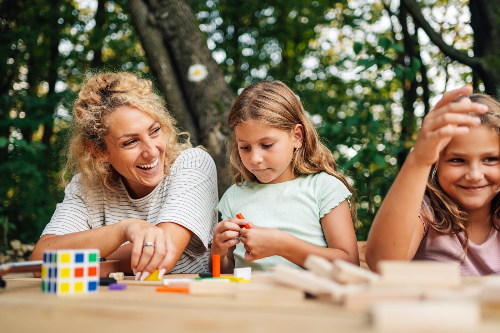 A cheerful family is playing a fun game in nature with wood bloc Family playing together outdoors