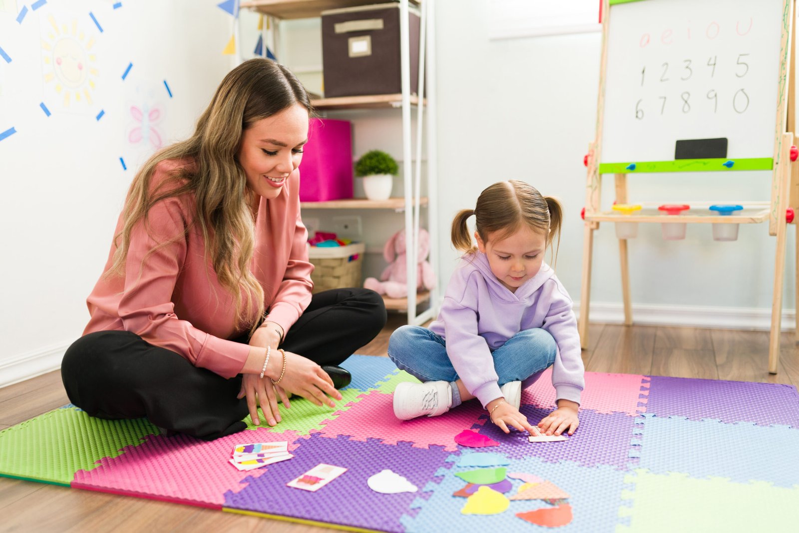 A child working on a puzzle with a therapist A child working on a puzzle with a therapist